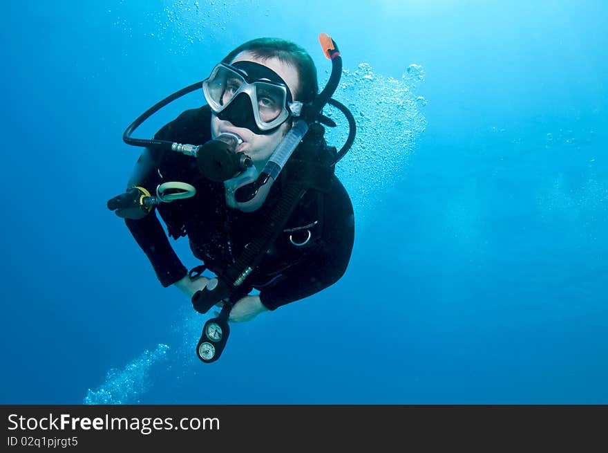 Man scuba diver swims in blue water. Man scuba diver swims in blue water