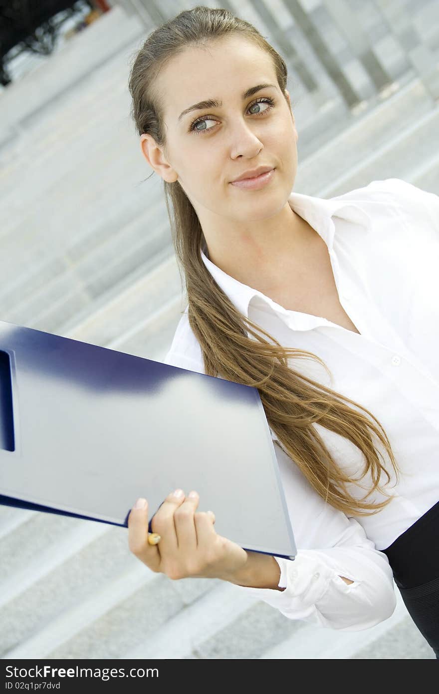 Attractive young businesswoman smiling with a folder. Attractive young businesswoman smiling with a folder