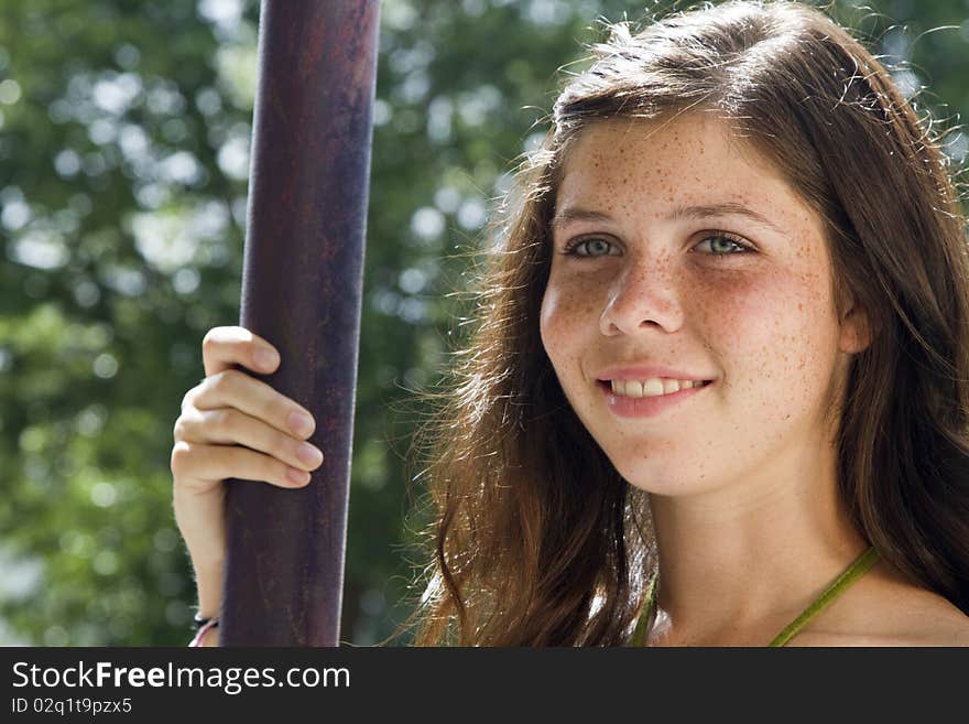 A pretty smiling freckled faced teenage girl with sunlit hair and green eyes gazes off into the distance. A pretty smiling freckled faced teenage girl with sunlit hair and green eyes gazes off into the distance.