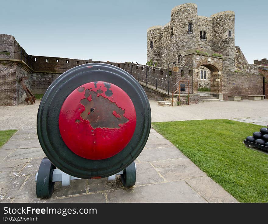 Close up view of an old canon, with a castle in the background. Image captured with an ultra wide angle lens, accentuating the proximity of the canon and distance of the castle. Close up view of an old canon, with a castle in the background. Image captured with an ultra wide angle lens, accentuating the proximity of the canon and distance of the castle