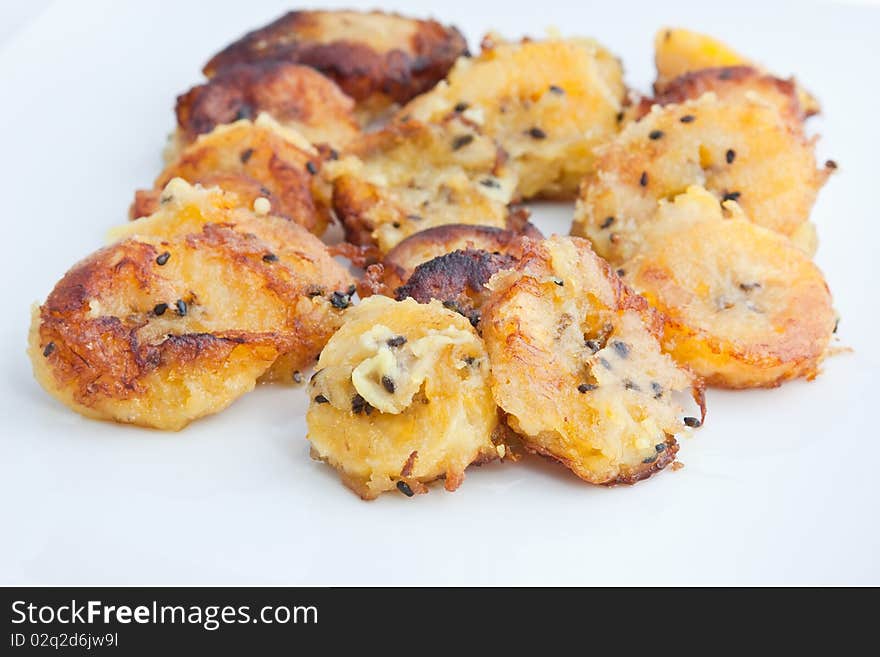 Banana, or plantain, boli. Ripe platain pieces fried on a rice flour batter with black sesame seeds. Banana, or plantain, boli. Ripe platain pieces fried on a rice flour batter with black sesame seeds