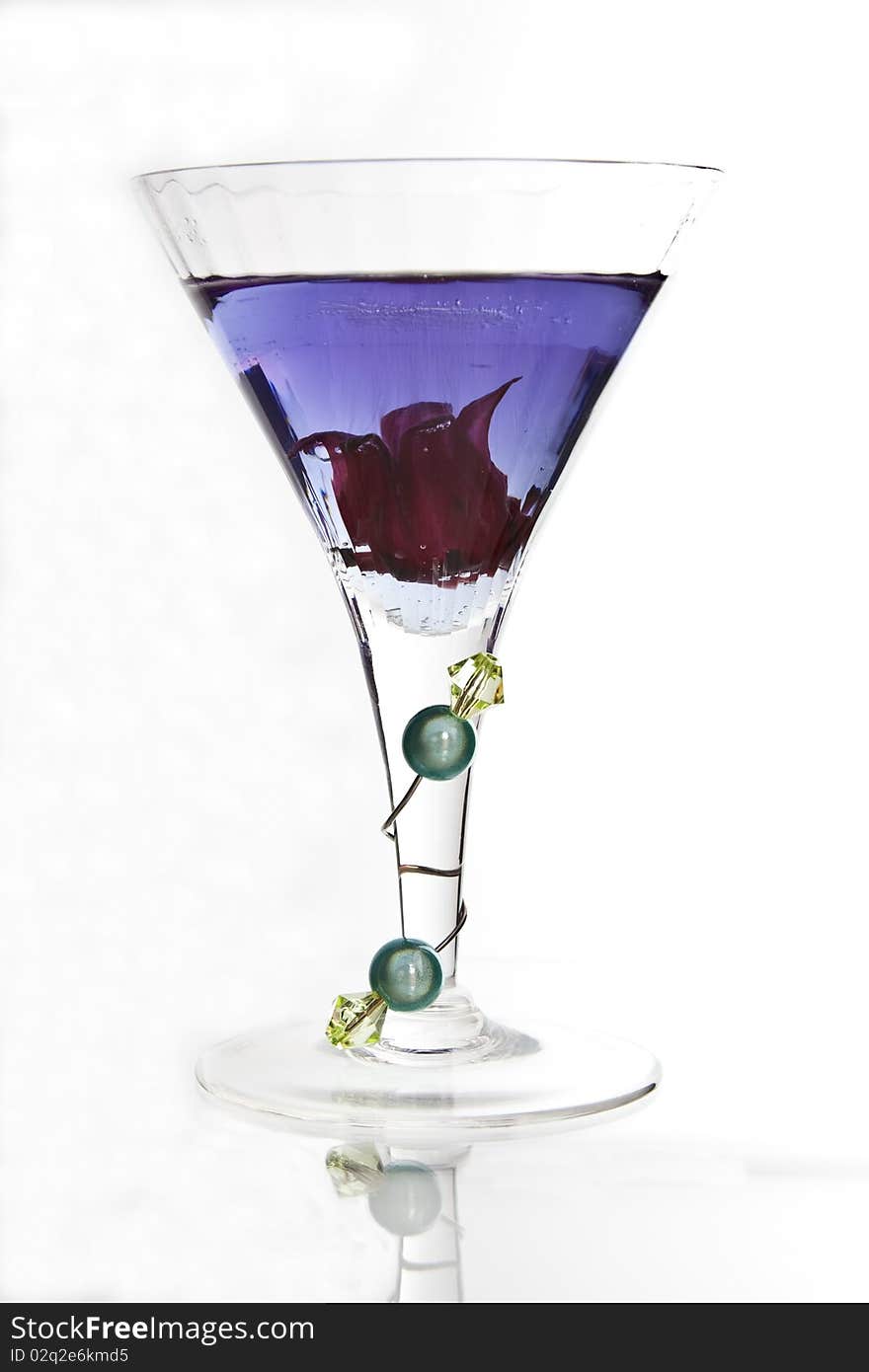 A cocktail glass with decorated glass stem containing a violet drink. A cocktail glass with decorated glass stem containing a violet drink