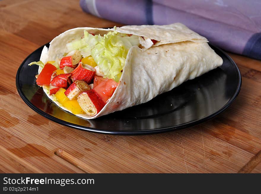 Clsoeup surami kebab with lettuce, pepper and tomato on black plate. Clsoeup surami kebab with lettuce, pepper and tomato on black plate.