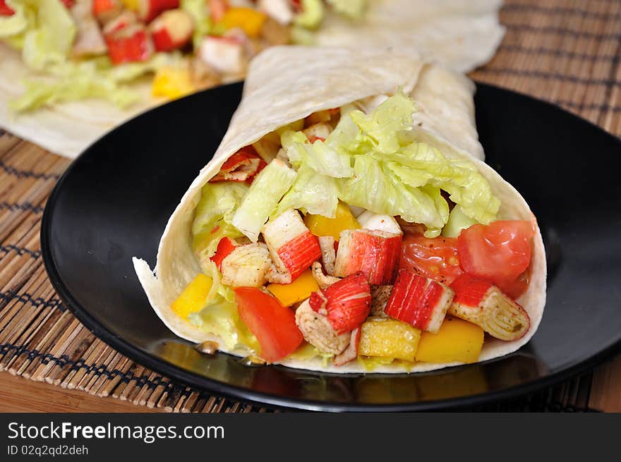 Clsoeup surami kebab with lettuce, pepper and tomato on black plate. Clsoeup surami kebab with lettuce, pepper and tomato on black plate.