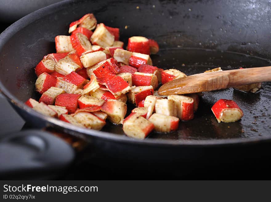 Pile of surami cube on olive oil in black pan. Pile of surami cube on olive oil in black pan