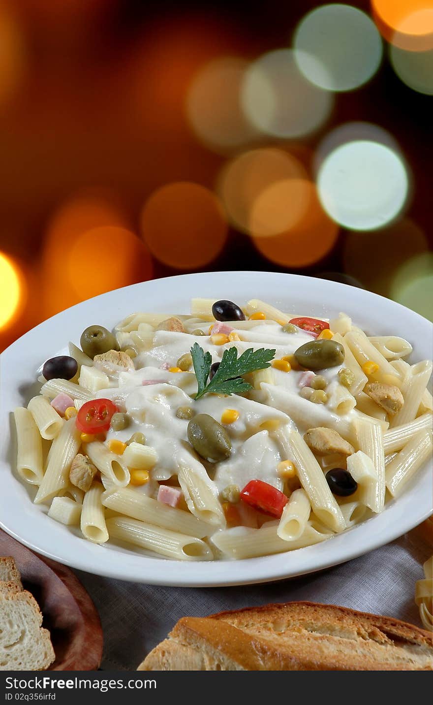 Italian cuisine, penne with white sauce and green olives