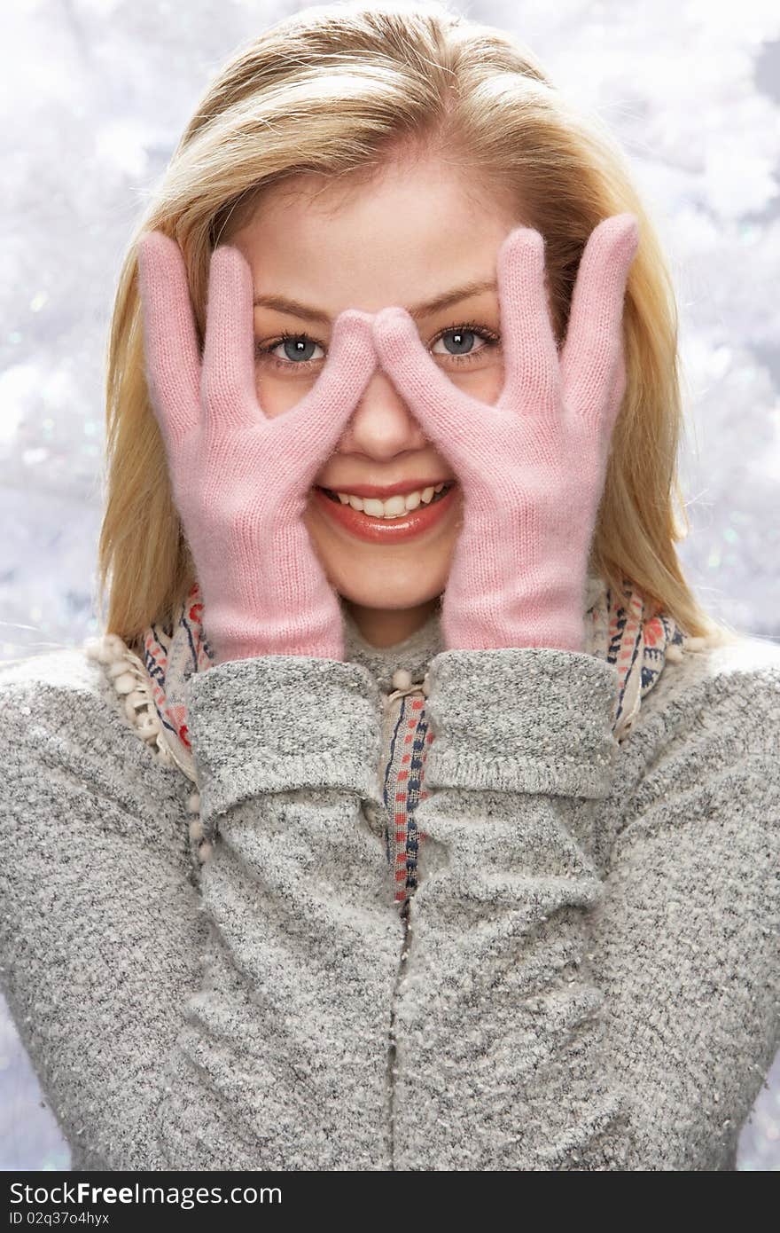 Fashionable Teenage Girl Wearing Cap And Knitwear In Studio In Front Of Christmas Tree