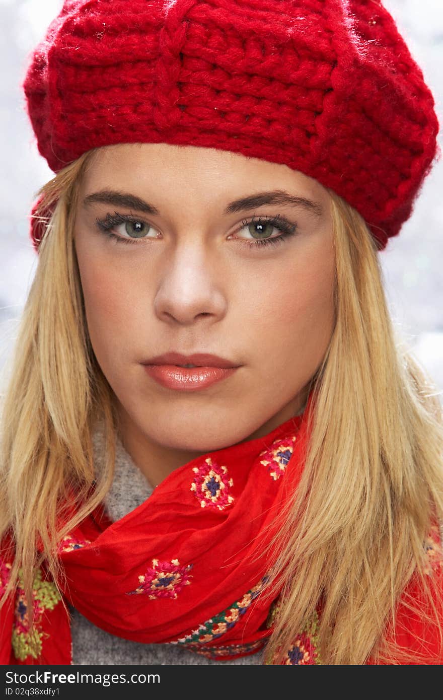 Fashionable Teenage Girl Wearing Cap And Knitwear In Studio In Front Of Christmas Tree