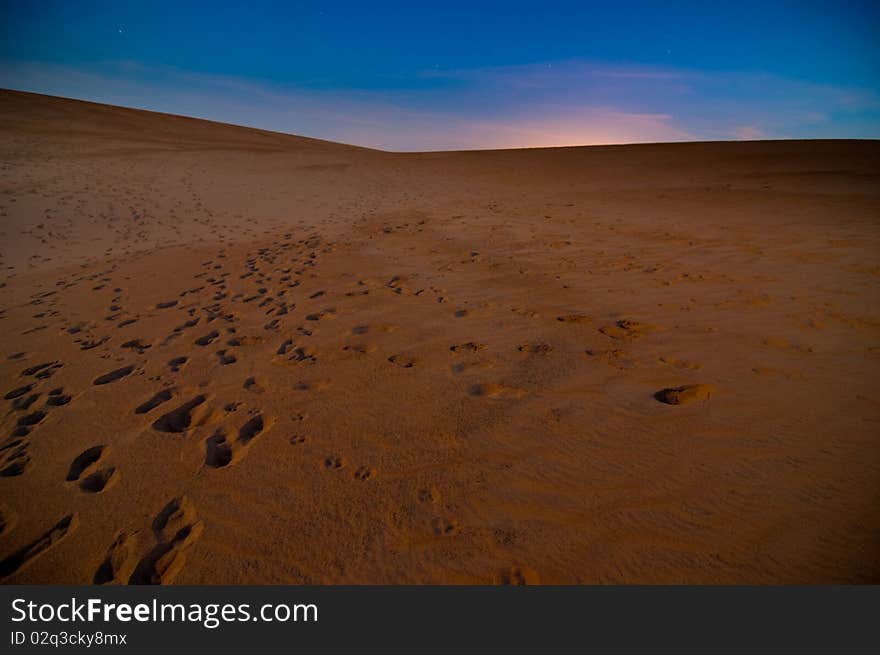 Sand dunes with footprints at sunrise. Sand dunes with footprints at sunrise