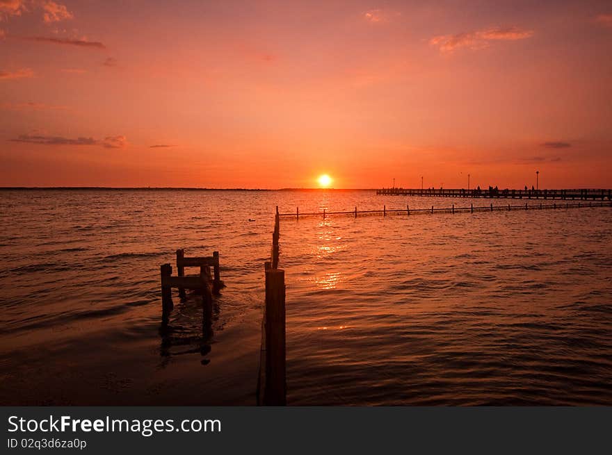 Sunset over water and dock. Sunset over water and dock