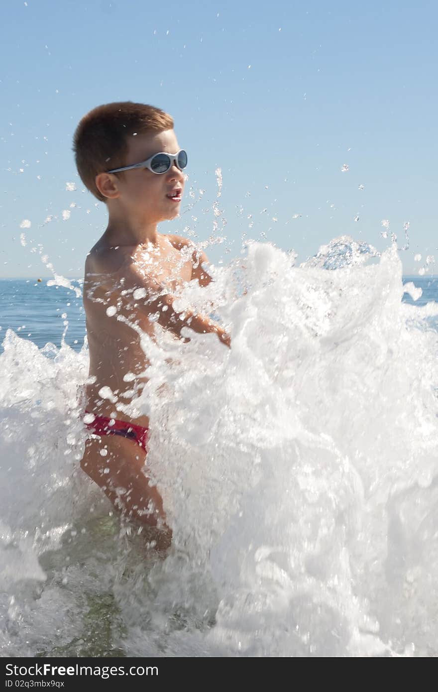 Child on the beach playing with waves