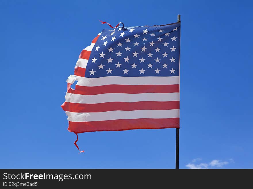 An American flag that is falling apart after flying for so long. An American flag that is falling apart after flying for so long.