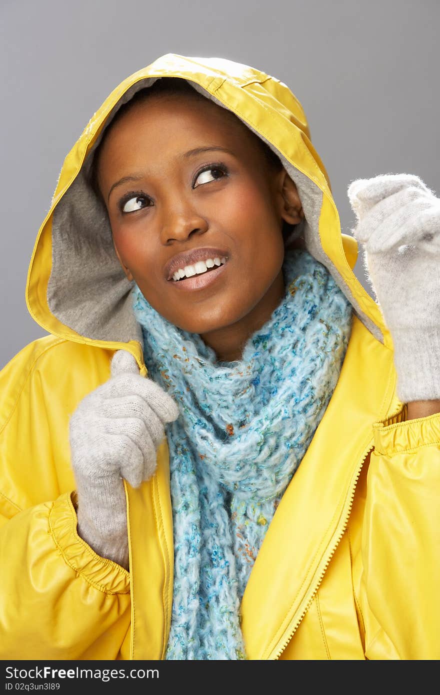 Young Woman Wearing Yellow Raincoat In Studio