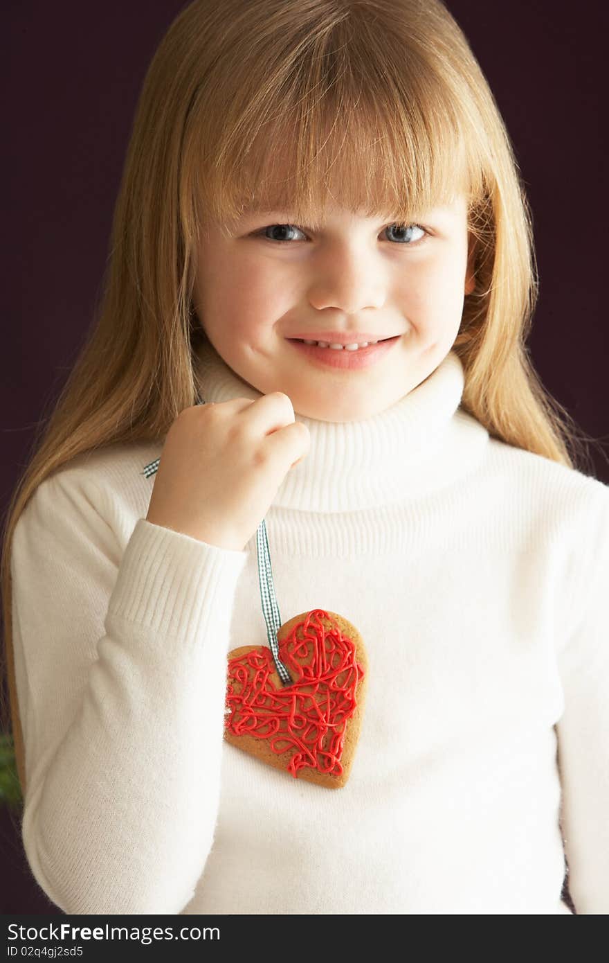 Young Holding Heart Shaped Cookie In Studio