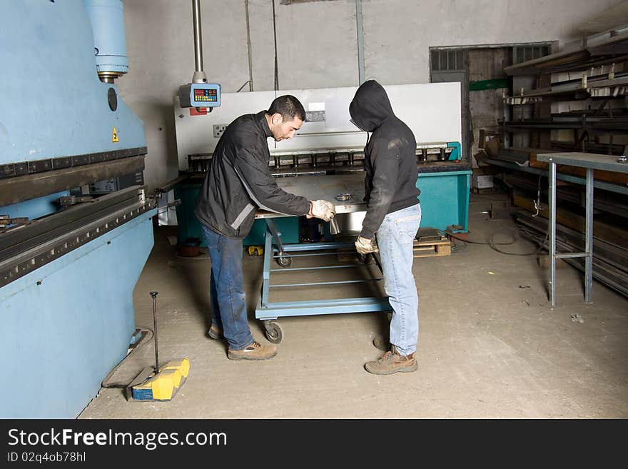 Metalworkers at work in their workshop forging the iron. Metalworkers at work in their workshop forging the iron