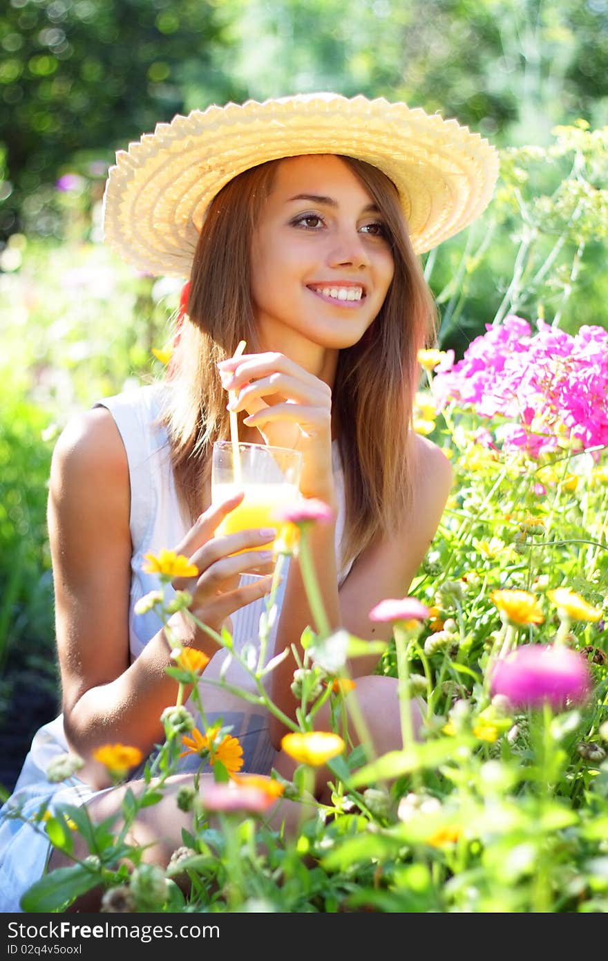 Beautiful girl drinking juice on a light background