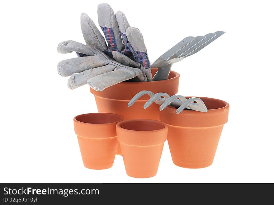 Steel rake on white background near to ceramic pots. Steel rake on white background near to ceramic pots.