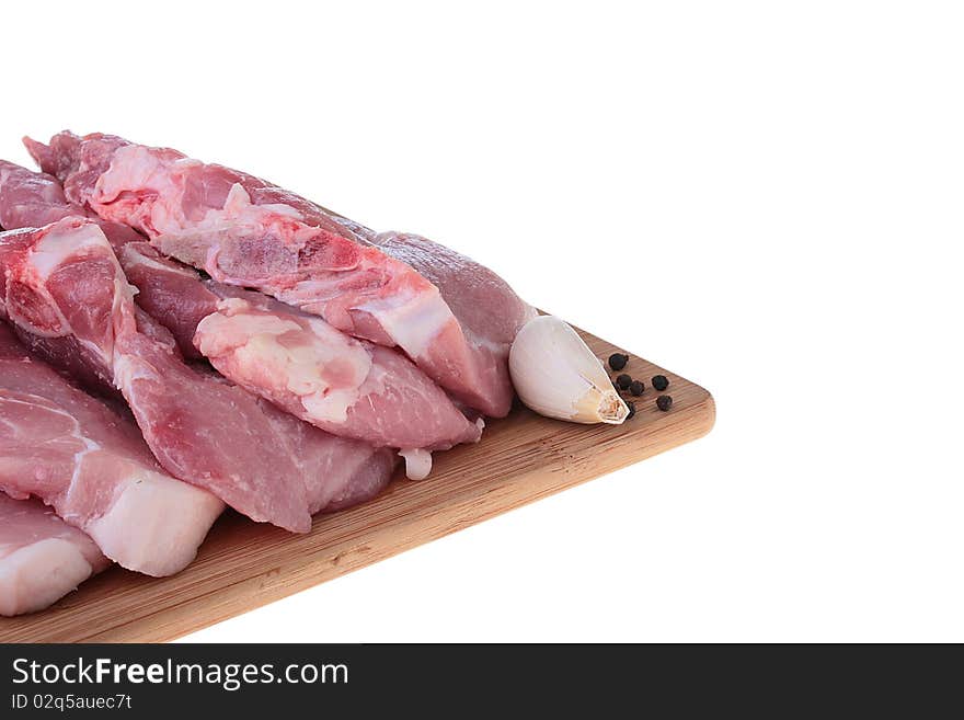 Piece of crude meat with black pepper on a kitchen board. Piece of crude meat with black pepper on a kitchen board.