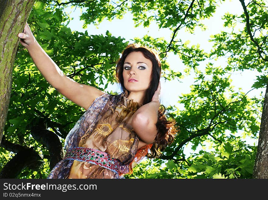 Young Brunette Girl Is Standing In A Brown Dress