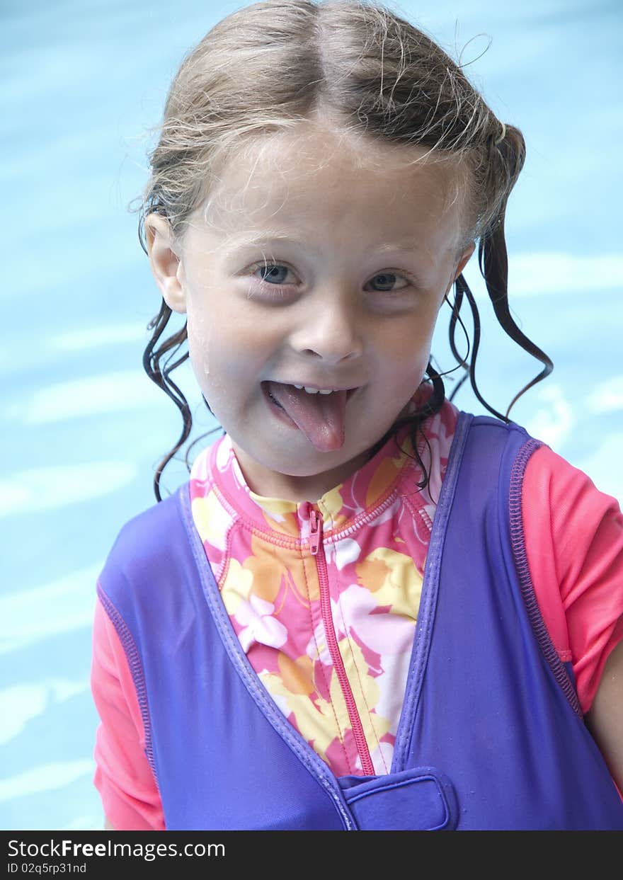 Photo image of a happy little girl in a swimming pool making a funny face. Photo image of a happy little girl in a swimming pool making a funny face