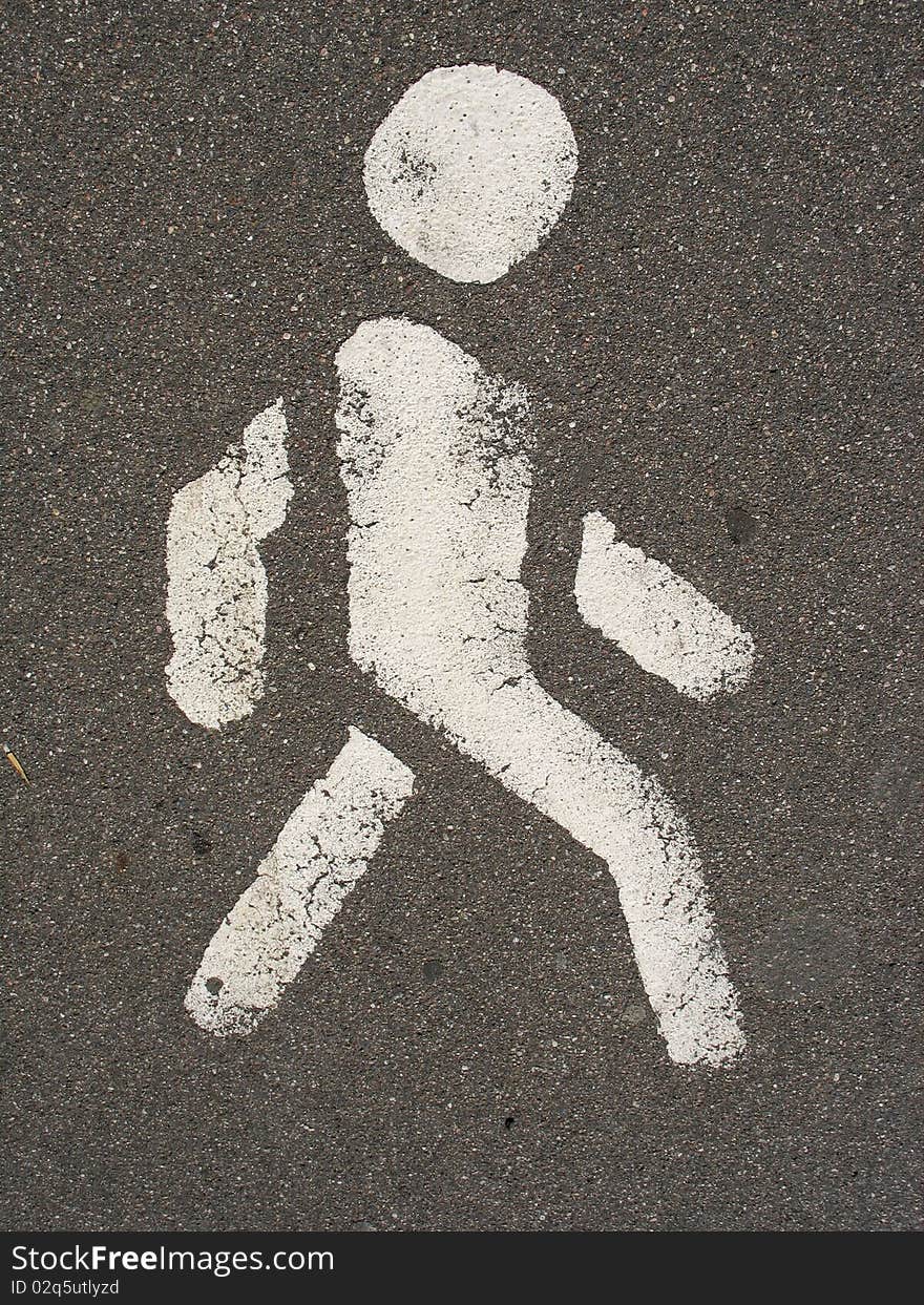 White painted man over black asphalt surface. White painted man over black asphalt surface