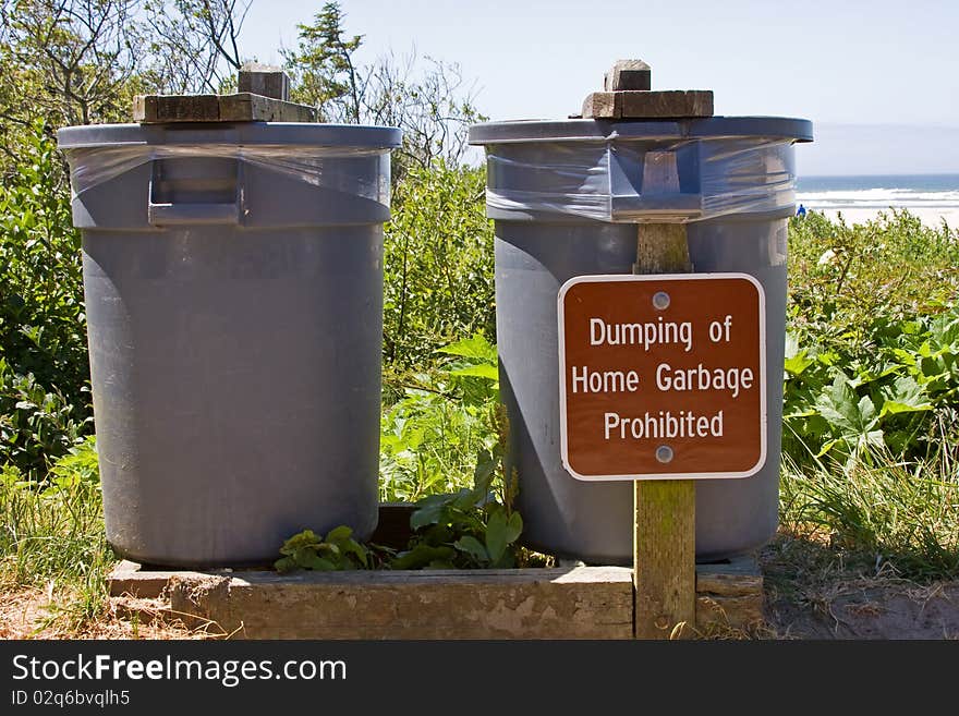 Public trash cans with prohibiting sign.