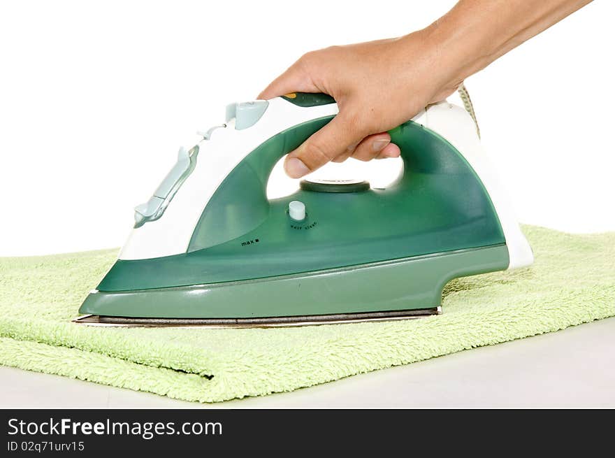 Hand with an iron and ironing a towel on white background