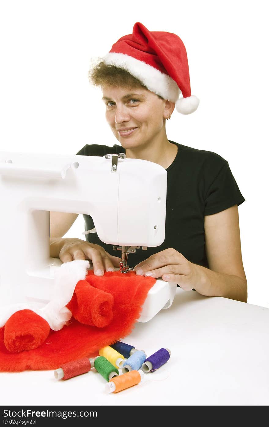 Woman sewing a fur coat for Santa Claus on the sewing machine