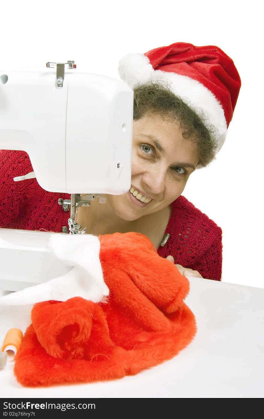 Woman sewing a fur coat for Santa Claus