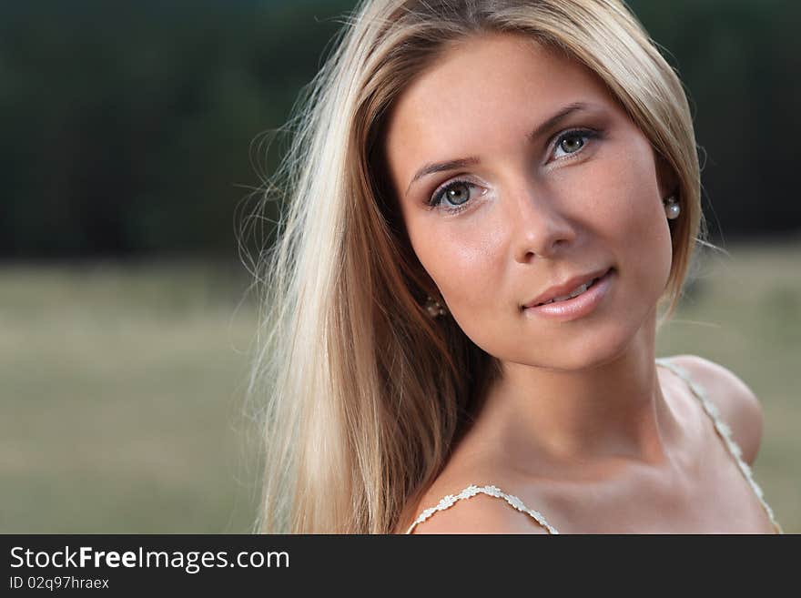 Beautiful young woman posing over green landscape. Beautiful young woman posing over green landscape.