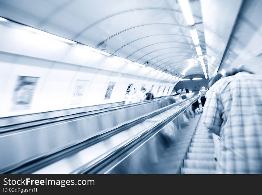 People on escalator in subway. Abstract motion picture.