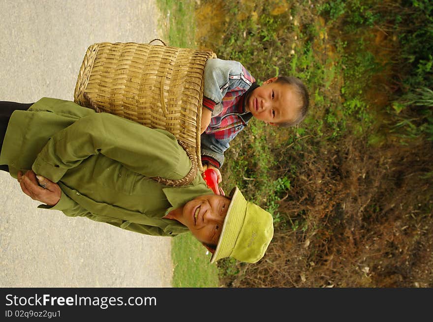 Grandfather Hmong and her small son in the cart. The road is long and the baby is tired. Grandfather Hmong and her small son in the cart. The road is long and the baby is tired.