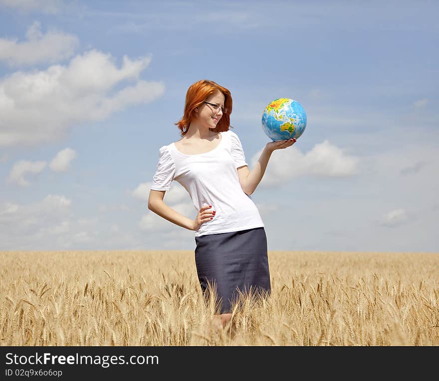 Young Businesswomen in white keeping globe in hand at wheat field