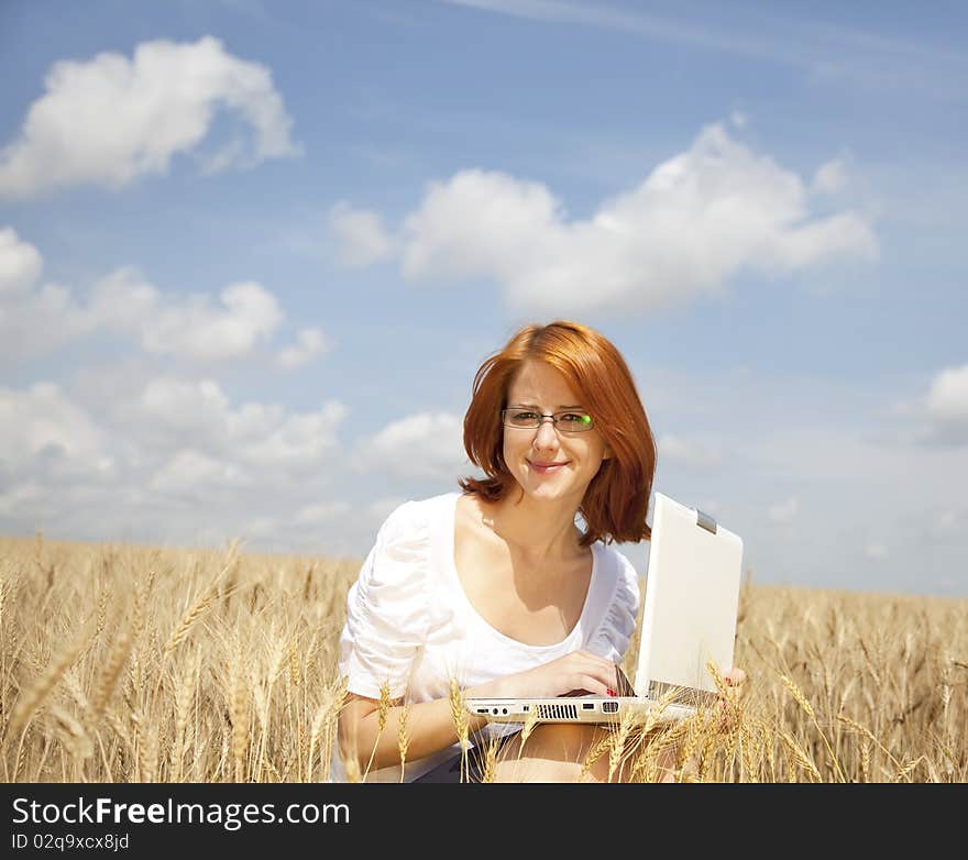 Young Businesswomen in white working with notebook at wheat field. Young Businesswomen in white working with notebook at wheat field.