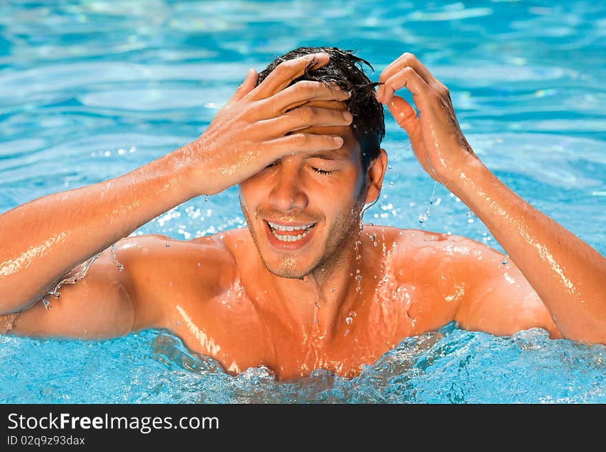 Cute attractive smiling laughing man in swimmingpool relaxing summerholiday vacations