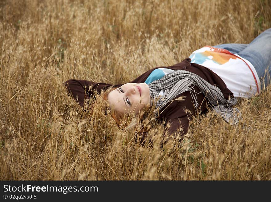 Young Beautiful Girl Lying At Yellow Autumn Field.