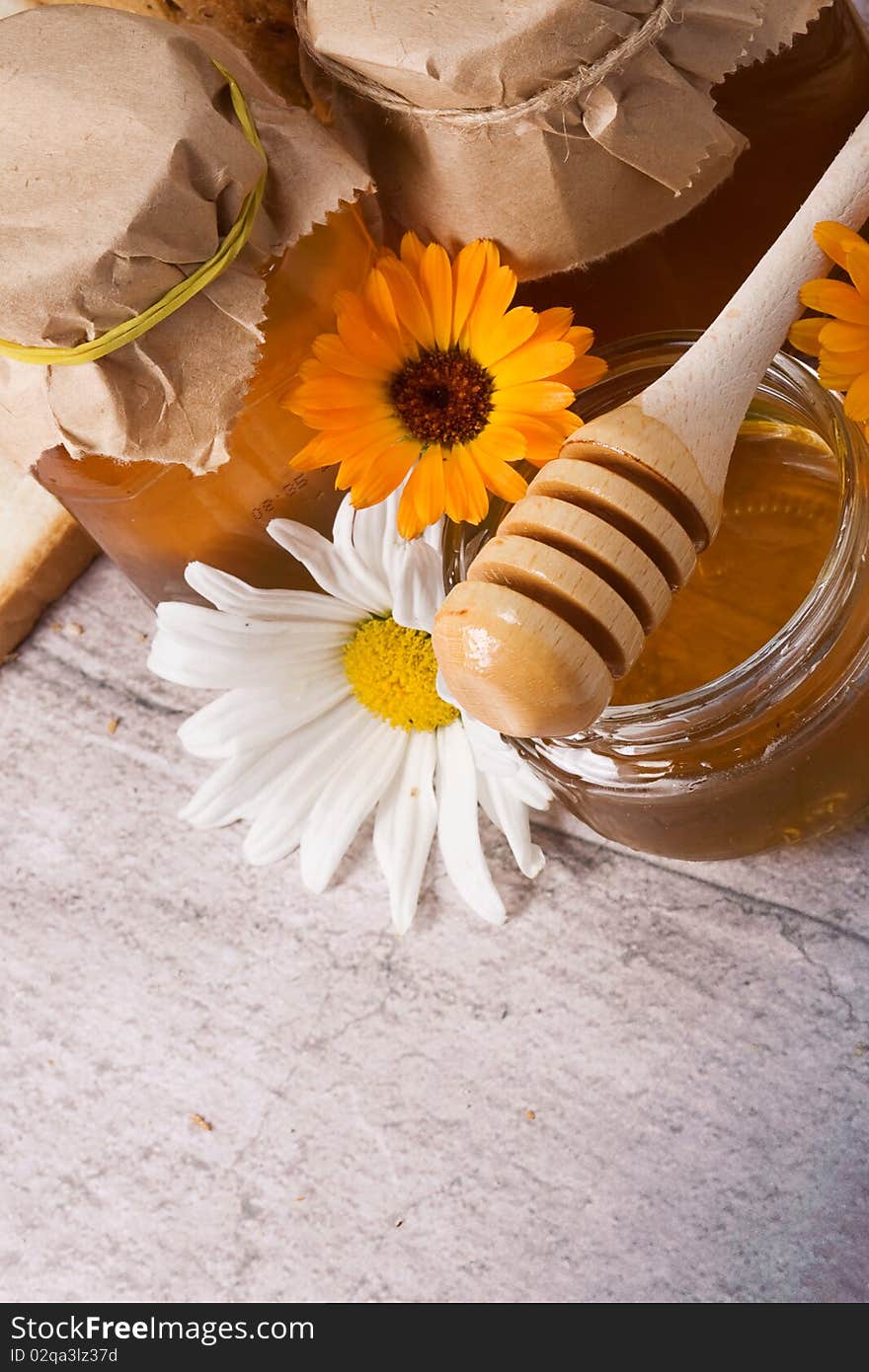 Several flowers and honey on table