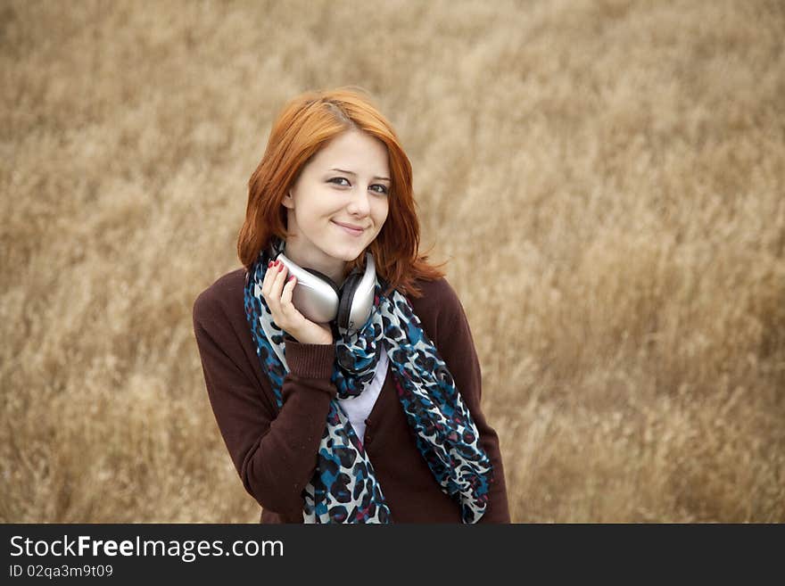 Young girl with headphones at field.