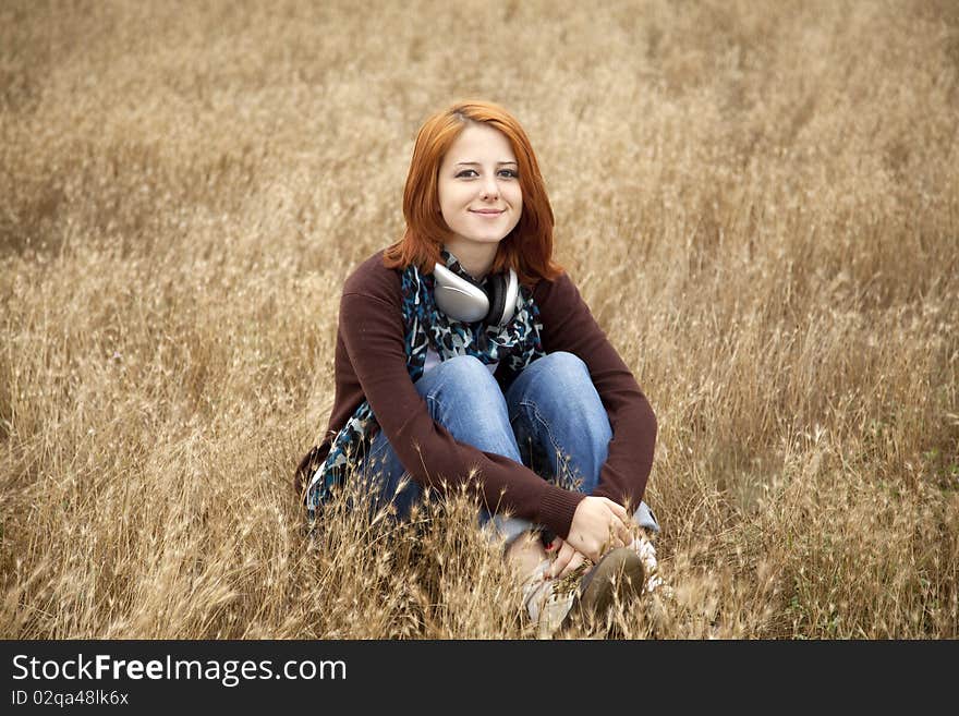 Young girl with headphones at field.