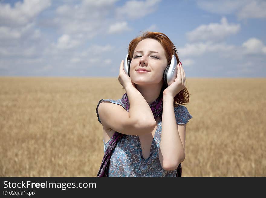 Young smiling fashion with headphones at wheat field. Young smiling fashion with headphones at wheat field.