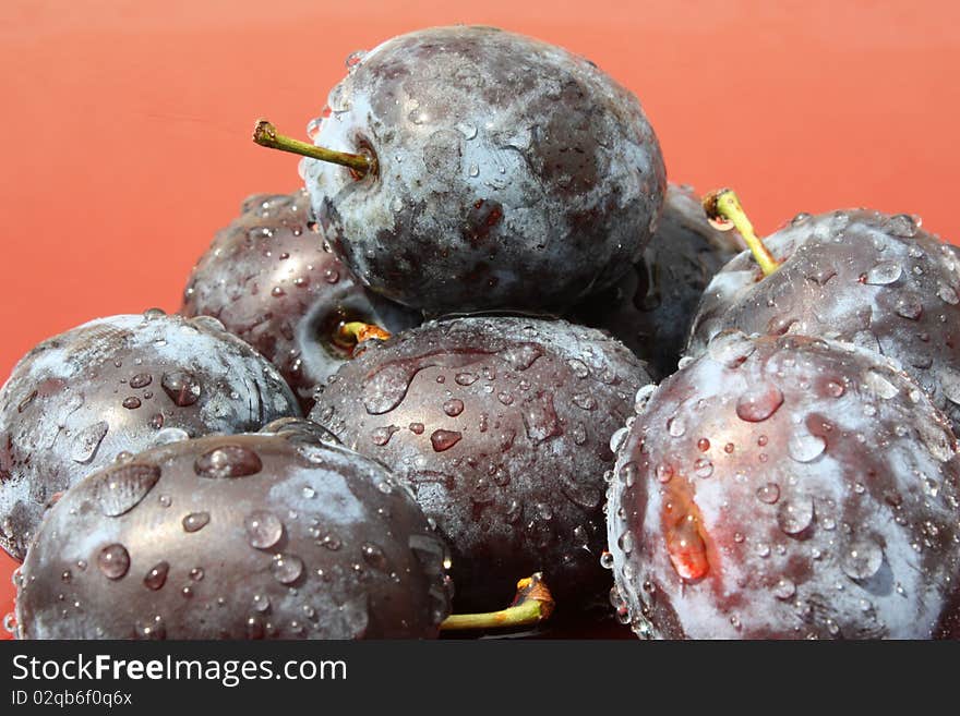 Fresh plums on red background. Fresh plums on red background.