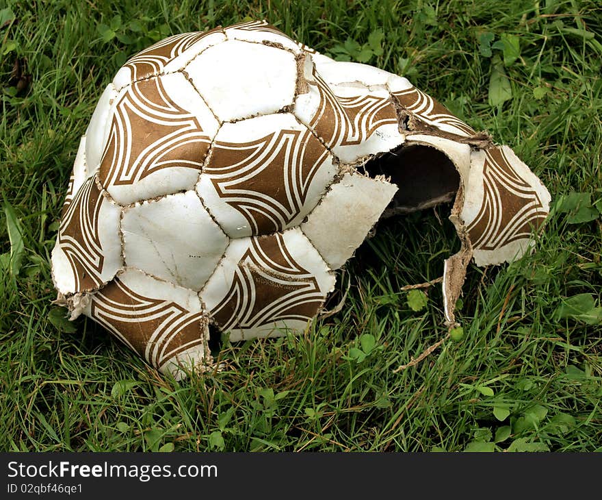 The broken off football on a green grass. The broken off football on a green grass.