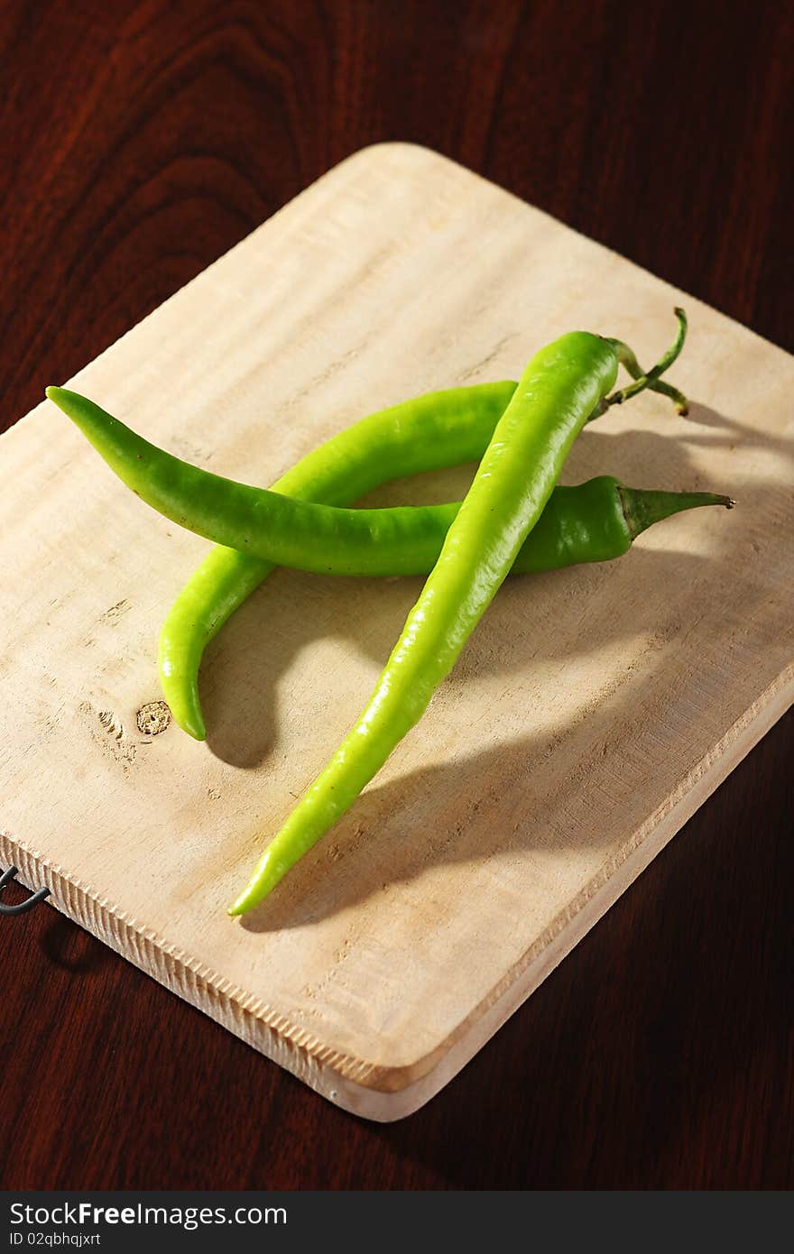 Chilis on wooden chopping board