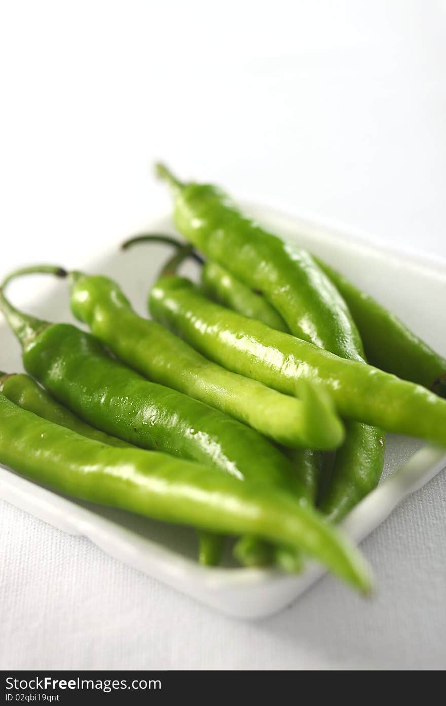 Green chilis on white