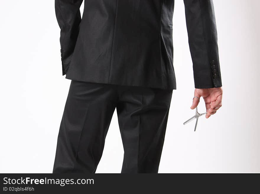 A back of a man holding a scissor in his hand. A back of a man holding a scissor in his hand