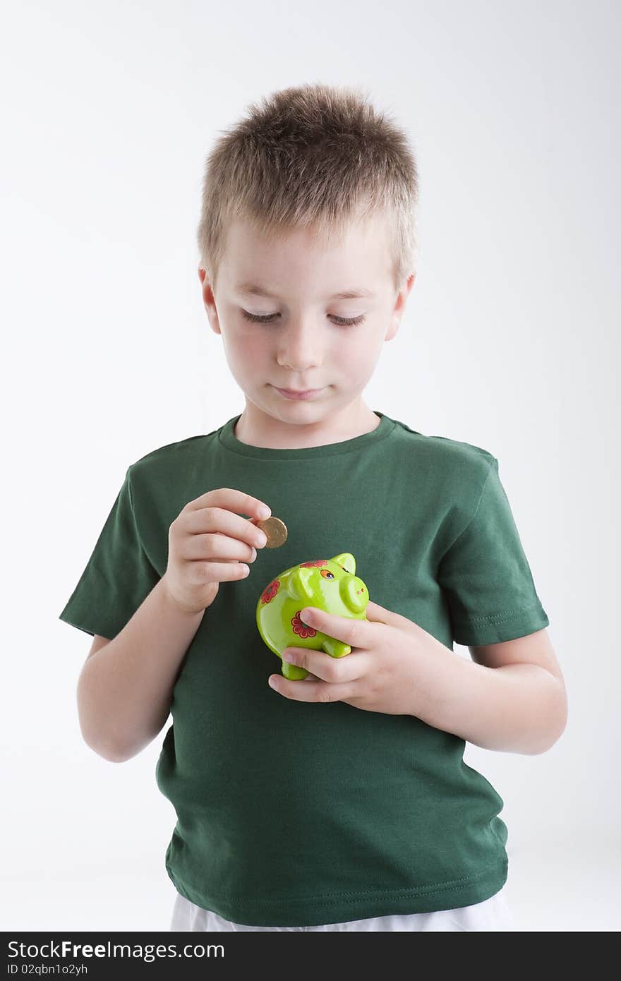 Little boy depositing money in his piggy bank. Concept: my future