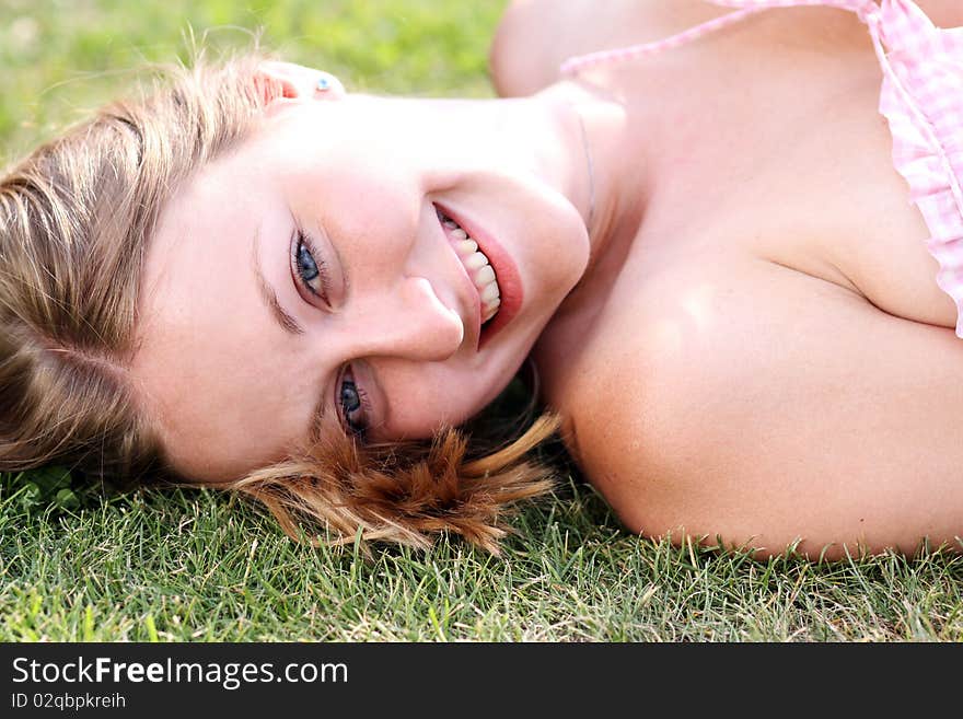 Cute young female lying on grass field at the park. Cute young female lying on grass field at the park