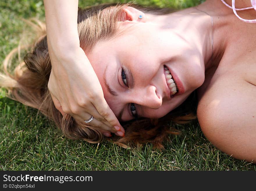 Cute young female lying on grass field at the park. Cute young female lying on grass field at the park