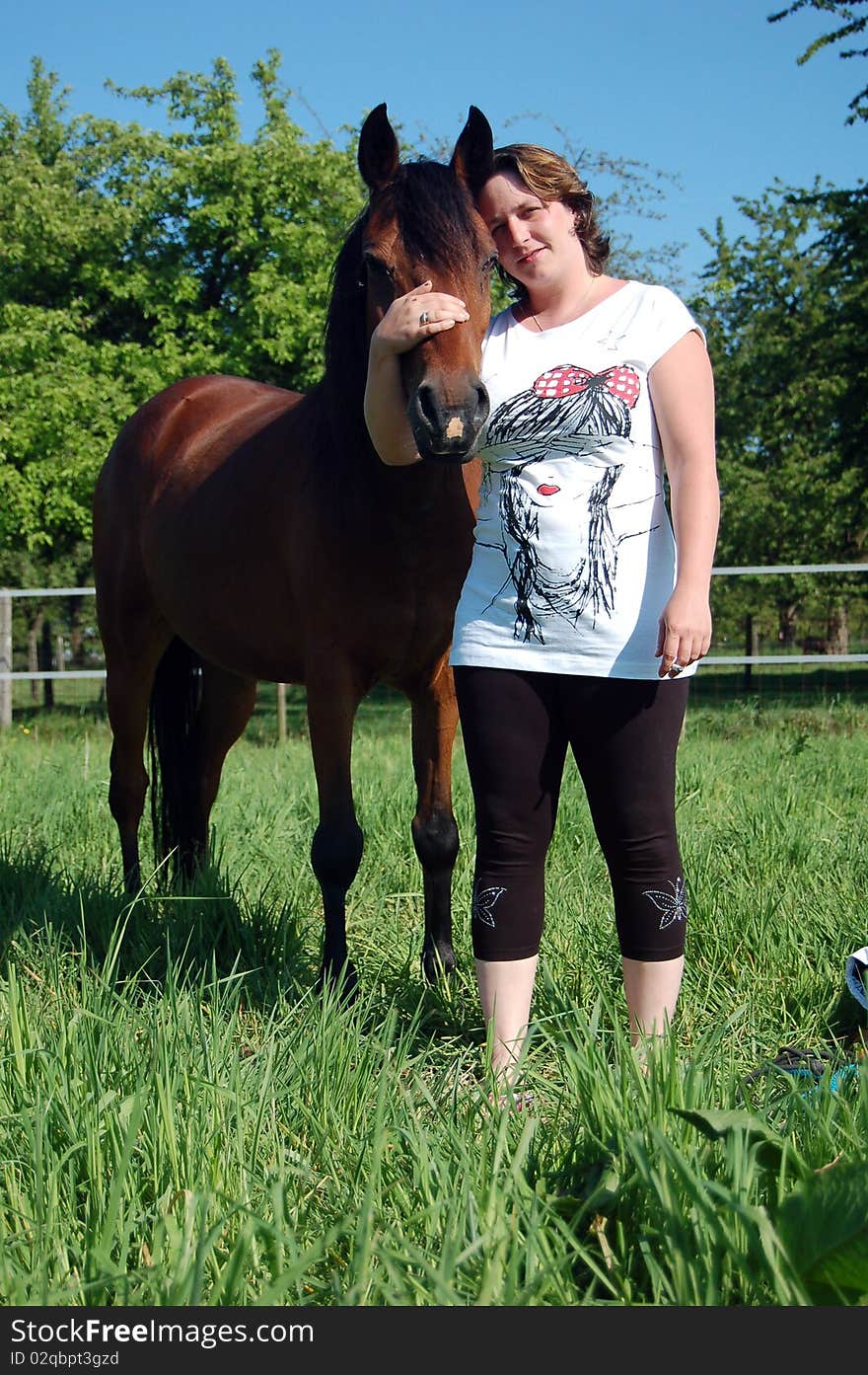 A woman with a brown New Forest pony. A woman with a brown New Forest pony.