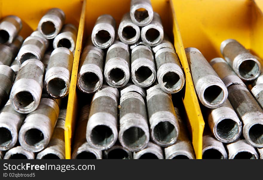 Iron pipes in a yellow shelf, Metallic products. Iron pipes in a yellow shelf, Metallic products